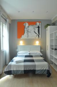 瓦伦西亚La Casa Verde - Ruzafa的卧室配有一张床铺,墙上挂有橙色画