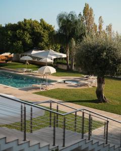 斯佩隆加格罗塔狄缇贝里欧酒店的享有带遮阳伞的游泳池的景色