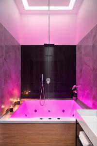 那不勒斯MAIN - Duomo的浴室设有粉红色的浴缸,配有粉红色的照明