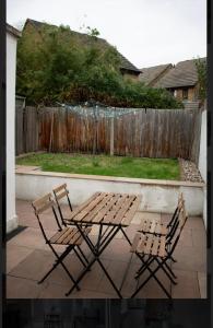 布伦特福德Brentford Guest Rooms的庭院设有两把椅子和一张野餐桌