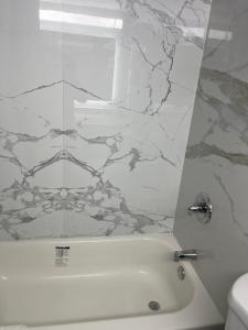 韦恩The Wayne Inn的浴室配有白色浴缸和大理石墙。