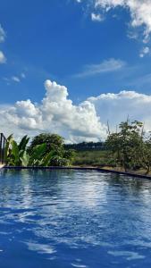 卡皮托利乌Suítes Canaã的一座蓝天云的游泳池