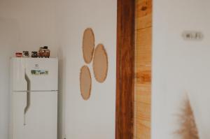 卡拉伊瓦Casinhas da Serena - Casa concha的厨房配有白色冰箱和带 ⁇ 珀姆伯姆伯姆伯姆伯姆(mbermbermbermbermbermbermbermber)的墙壁