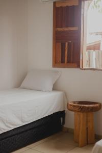 卡拉伊瓦Casinhas da Serena - Casa concha的一间带床和凳子的小卧室
