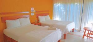 科米坦德多明格斯Hotel Central Comitán的酒店客房设有两张床和一张桌子。