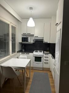 约恩苏Tilava yksiö Niinivaaralla的厨房配有白色家电和桌椅