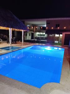 MarcelinoRancho Del Oso Tuerto的夜间大型蓝色游泳池