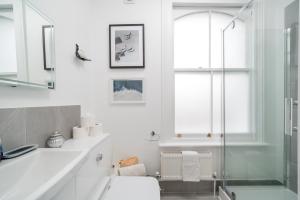伦敦Niru Experience Royal Deluxe 4BD 2BA Apt的带淋浴、卫生间和盥洗盆的浴室