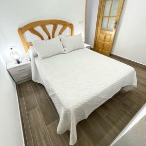 PuertoBajo Derecha el Wiro的卧室配有白色的床和木制床头板