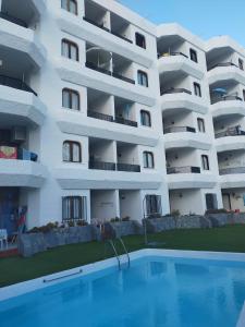 莫甘Balcón Puerto Rico Playa Mogán的公寓大楼前方设有游泳池
