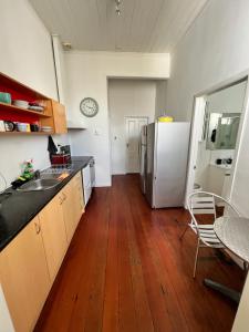 奥克兰Grey Lynn House Auckland的带冰箱的厨房和木地板