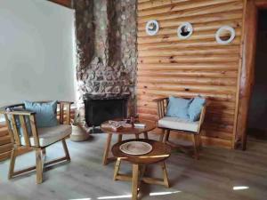 本塔纳山村Balcon del Golf的客厅配有两把椅子、一张桌子和壁炉
