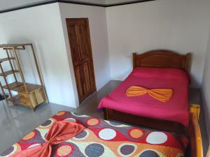希门尼斯港Casa Osa Azul的一间卧室配有一张带粉红色床罩和弓形领带的床。