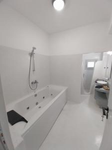 佩里萨East Wind Perissa的白色的浴室设有浴缸和水槽。