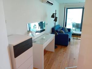 直布罗陀Urban Oasis at Luxurious Ocean Village的客厅配有白色的办公桌和蓝色的沙发。
