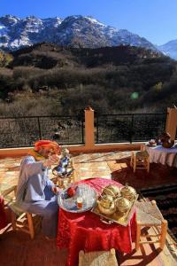 伊姆利尔Dar Amadine的坐在山地庭院桌子上的女人