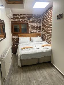 伊斯坦布尔GRAND BELLA VİSTA Hostel的卧室设有一张砖墙内的大床