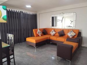 特鲁希略Apartamentos "APPART D'ELIETTE"的客厅配有橙色沙发和镜子