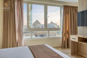 开罗Saray Pyramids & Museum View Hotel的一间卧室设有一张床和一个大窗户