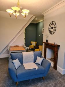 MytholmroydStunning River View的客厅配有蓝色的沙发和桌子