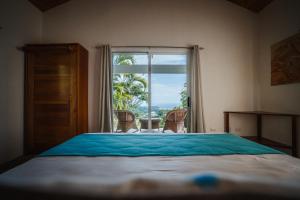 萨玛拉Lodge Las Estrellas de Samara的一间卧室设有一张床和一个大窗户