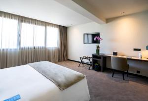 卡萨布兰卡JM Suites Hotel Eco-Friendly Casablanca的配有一张床和一张书桌的酒店客房