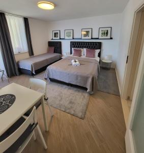 杜布罗夫尼克蓝星公寓的一间卧室配有两张床和一张桌子及椅子