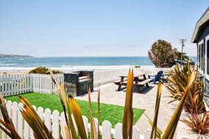 迪伦比奇Dillon Beach Resort的一个带白色围栏和海滩的后院