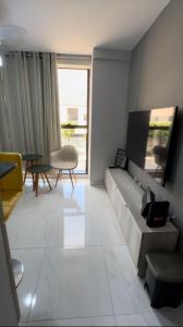 卡贝德卢Flat Praiano Aconchegante的客厅配有沙发和桌子