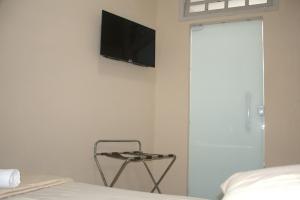 雷森迪Pé da Serra Hotel的卧室设有壁挂式电视和椅子