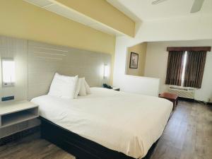 弗洛伍德弗洛伍德美国最佳酒店的一张大白色的床,位于酒店客房内