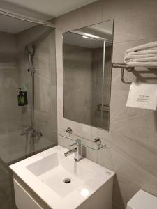 高雄慕晨旅店的浴室设有白色水槽和镜子