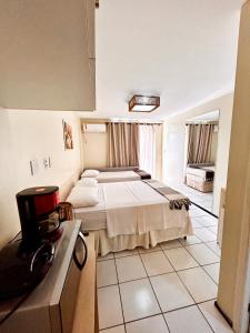 巴雷里尼亚斯Gran Lençóis Flat Residence Barreirinhas - Mandacaru 211的酒店客房带一张床和一个厨房