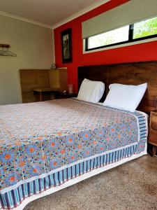 Cow Bay沃姆普生态休闲旅馆的一间卧室设有一张带红色墙壁的大床