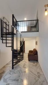 奥里萨巴Departamento Loft B的客厅设有螺旋楼梯和沙发