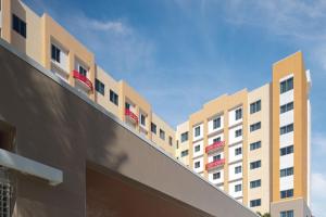 西棕榈滩Residence Inn by Marriott West Palm Beach Downtown的阳台上一排配有红色椅子的建筑