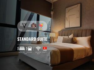 吉隆坡Scarletz Suites KLCC by De Harlequins Guesthouse的一间卧室配有一张标准套房标牌的床