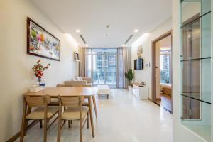 胡志明市Apartment in Landmark-Vinhome Central Park by Yen的用餐室以及带桌椅的起居室。