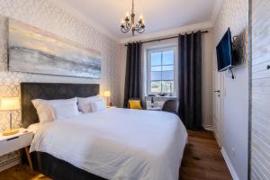 蒂索Hotel Villa Wahnfried Thiessow的卧室设有一张白色大床和一扇窗户。