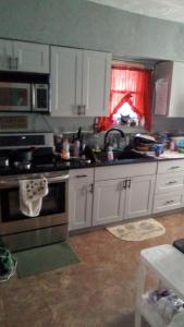 West HomesteadMountain house的厨房配有白色橱柜和炉灶烤箱。