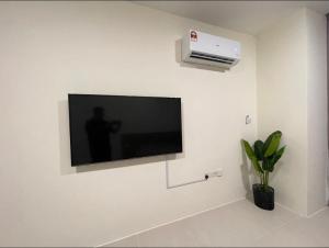 古晋J&SM Riverine resort homestay的挂在白色墙壁上的平面电视