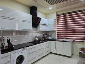 撒马尔罕Аппартаменты Rohat的厨房配有白色橱柜和洗衣机。