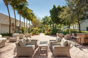 西棕榈滩西棕榈滩万豪酒店 的一个带沙发和桌子及棕榈树的庭院