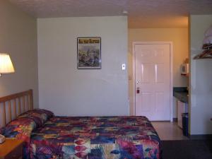 西沃德墨菲斯阿拉斯加酒店的卧室配有一张床,墙上挂着一幅画