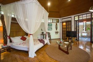 长滩岛Mandala Spa & Resort Villas的一间卧室配有一张带天蓬的床