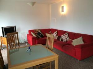 科克39号卡姆登码头公寓的客厅配有红色的沙发和桌子