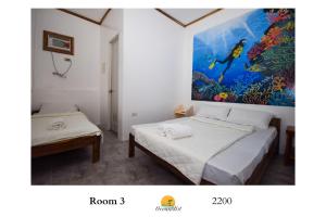 圣维森特Ocean Mist Tourist Inn的一间设有两张床的客房,墙上挂着一幅画