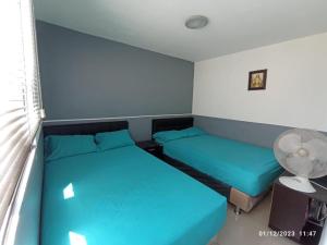 麦德林CENTRO! San Lorenzo - Downtown - Apartaestudio Familiar的小型客房配有2张床和风扇。