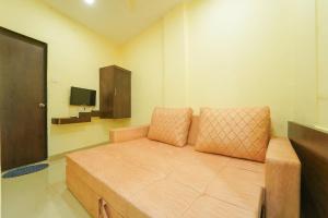 马哈巴莱斯赫瓦尔Berry Fresh Stays Mahabaleshwar With Pool的一间小房间,配有沙发和电视