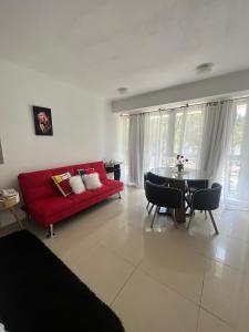 埃斯特角城Monoambiente Green Park- Solanas的客厅配有红色的沙发和桌子